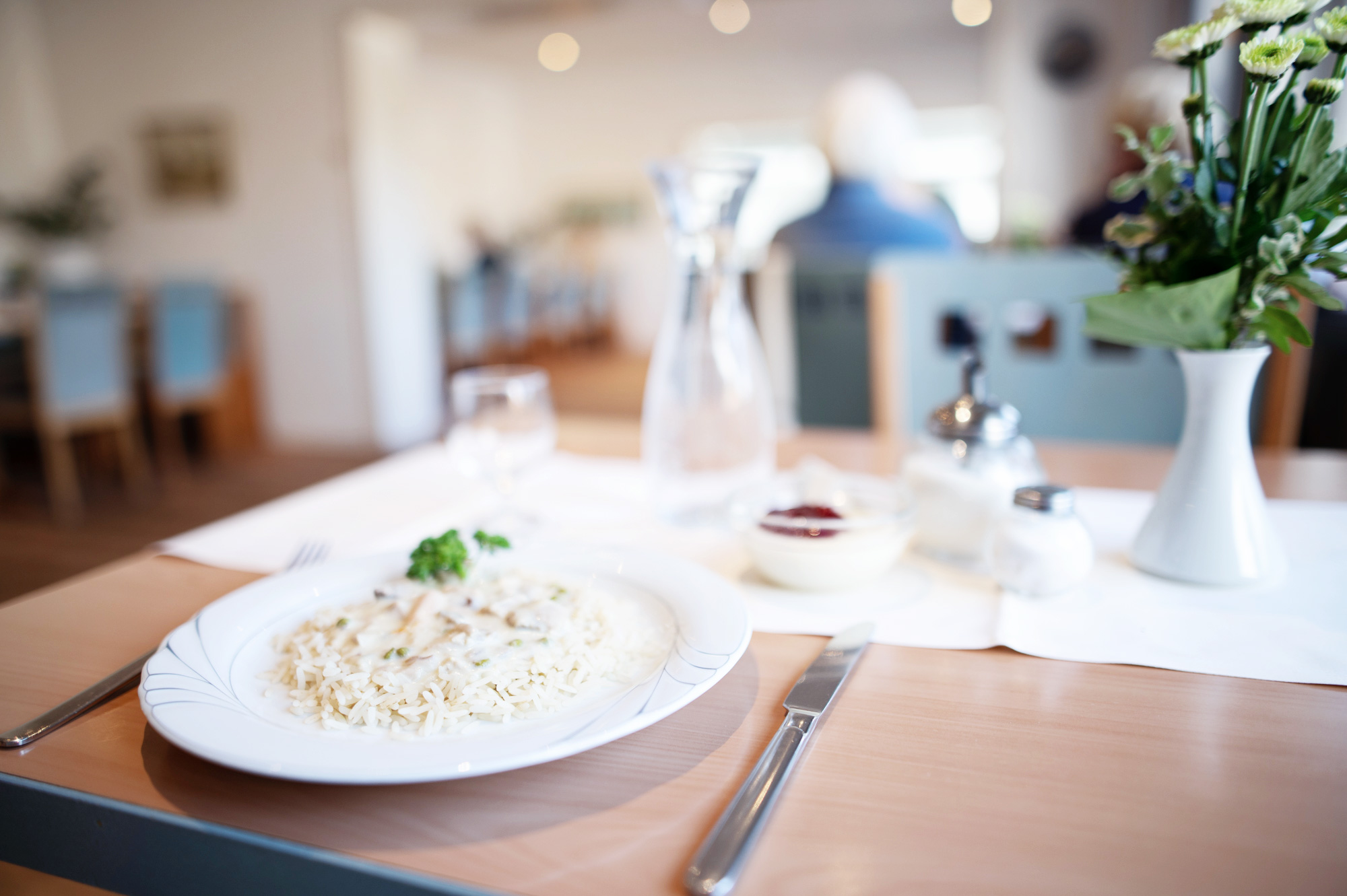 SoVD - Gedeckter Tisch im Restaurant vom Erholungszentrum Büsum mit Hühnerfrikassee, Nachspeise und Blumen