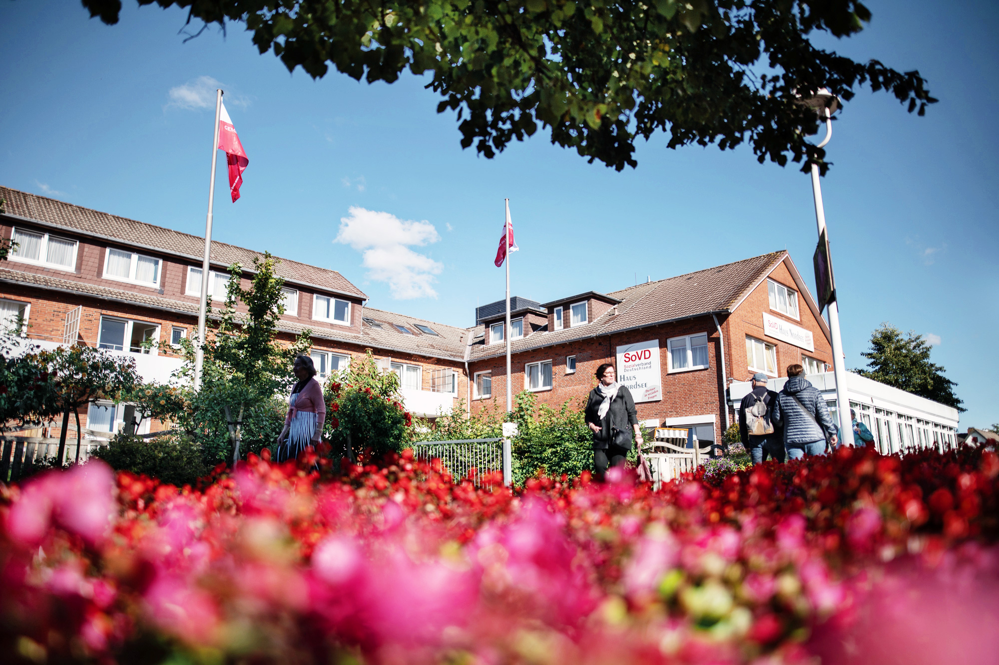 SoVD - laufende Personen vor dem Erholungszentrum Büsum Gebäude aus Froschperspektive